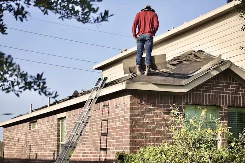 Professional roofer working on a residential roof in Wenham Neck